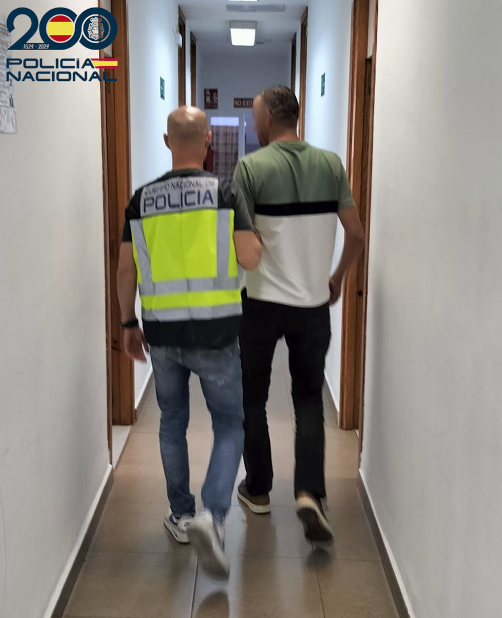 Archivo - Agente de policía con uno de los detenidos por hurtos en Palma