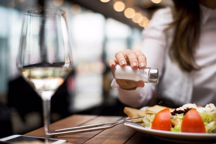 Archivo - Salero, comida en la mesa. Copa de vino blanco.