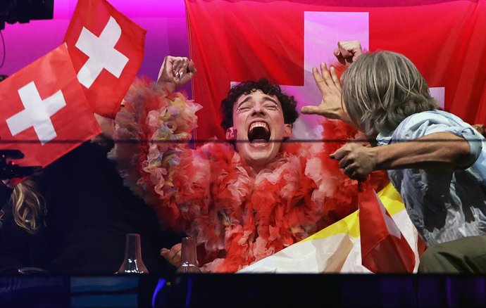 12 May 2024, Sweden, Malmo: Nemo (C) from Switzerland reacts during the scoring at the final of the Eurovision Song Contest (ESC) 2024 in the Malmo Arena. Photo: Jens Büttner/dpa