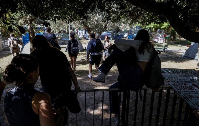 Estudiants de la Universitat de València salten la tanca per a arribar a la Facultat de Filosofia i Ciències de l'Educació, en el marc de l'acampada propalestina. 