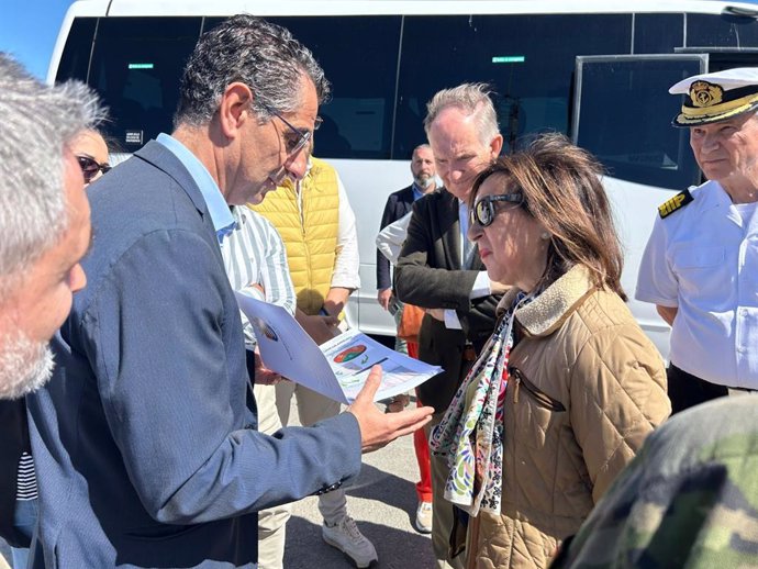 El alcalde de Barbate (Cádiz), Miguel Molina (Andalucía Por Sí), entrega a la ministra de Defensa, Margarita Robles, el Plan de Singularidad del municipio en un encuentro forzado en el campo de adiestramiento Sierra del Retín