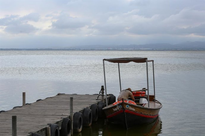 Archivo - Arxiu - Un tripulant espera en la seua barca atracada en l'embarcadero del Parc Natural de l'Albufera