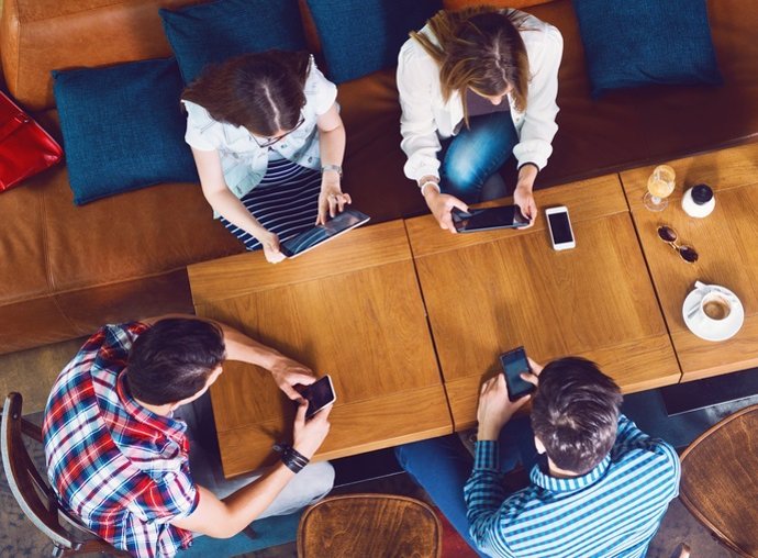 Archivo - Group of young people sitting at a cafe, top view