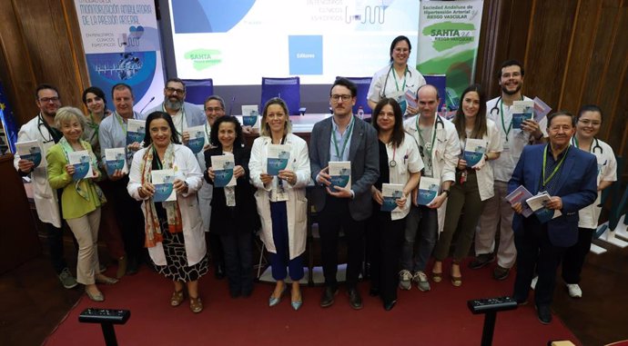 Autores y asistentes al acto de presentación muestran el manual 'Utilidad de la monitorización ambulatoria de la presión arterial en fenotipos clínicos específicos'.