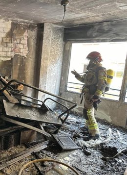 Un bombero de la ciudad de Huesca trabaja en la vivienda de la calle Ramón y Cajal incendiada esta tarde.