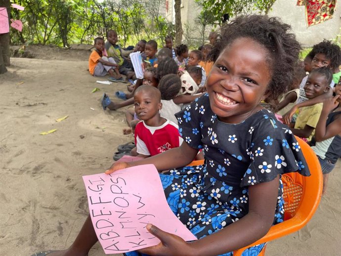 Afo es una niña muy feliz en su club de lectura en RDC, aprendiendo a leer y escribir con sus amigos.