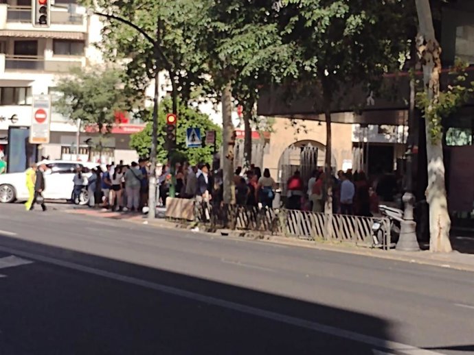 Personas esperando en la parada de autobús durante la Feria de Córdoba.