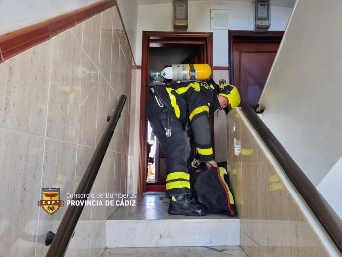 Uno de los bomberos en la entrada de la vivienda siniestrada.