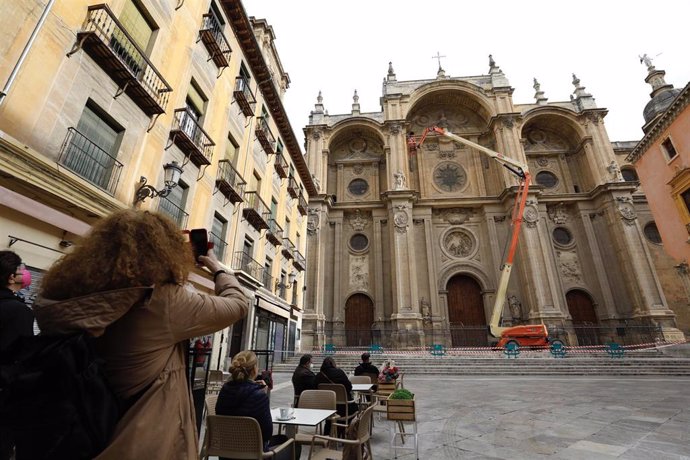 Archivo - Operarios revisan la fachada de la Catedral de Granada, en imagen de archivo