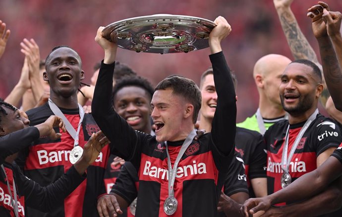 18 May 2024, North Rhine-Westphalia, Leverkusen: Leverkusen's Florian Wirtz celebrates with the championship trophy following the German Bundesliga soccer match between Bayer Leverkusen and FC Augsburg at BayArena. Photo: Marius Becker/dpa - IMPORTANT NOT