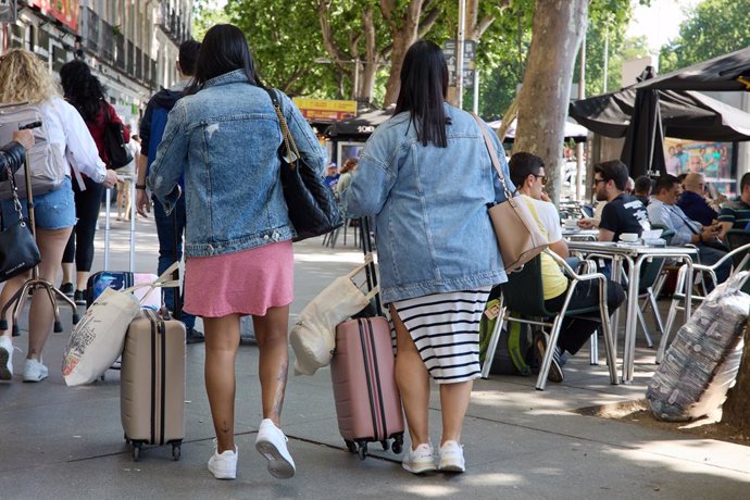 Archivo - Dos turistas caminan con sus maletas por el centro de la ciudad, a 3 de junio de 2023