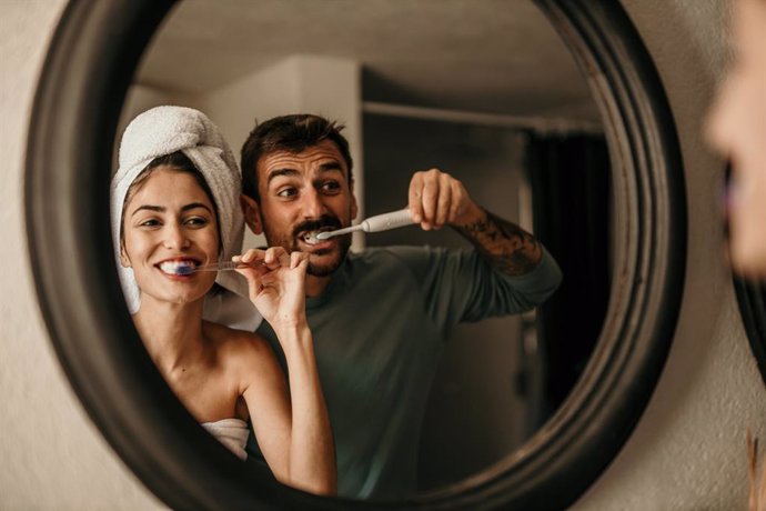 Archivo - A romantic moment unfolds as a couple stands side by side, brushing teeth and exchanging warm glances in their bathroom