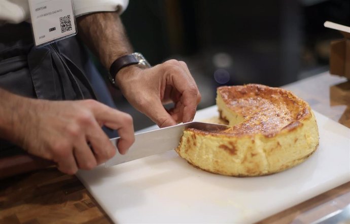 Archivo - Un camarero corta una porción de tarta de queso 