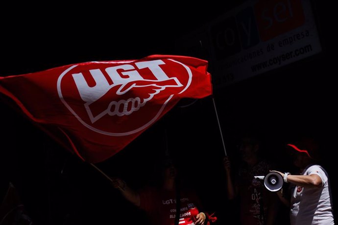 Archivo - Una persona ondea una bandera de UGT durante una huelga convocada por el sector de contact center, a 13 de mayo de 2022, en Madrid (España).