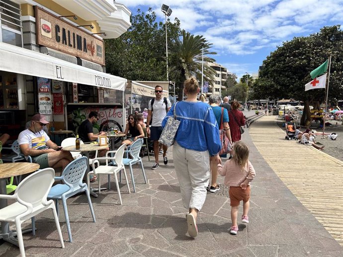 Imagen de recurso de turistas caminando por el paseo de la playa de El Médano, en Granadilla de Abona, en Tenerife.