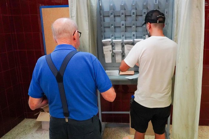 Archivo - Varias personas cogen papeletas para ejercer su derecho a voto durante las elecciones generales, en el Colegio Joaquín Turina, a 23 de julio de 2023, en Sevilla (España). (Foto de archivo).