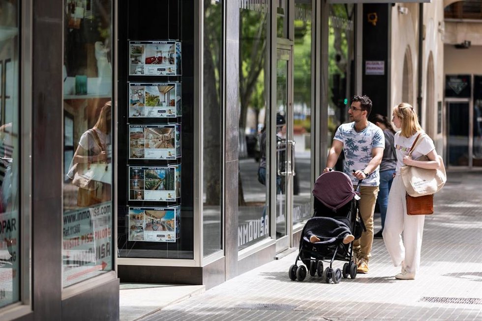 Dos personas observan los anuncios de viviendas en venta en una inmobiliaria, a 15 de abril de 2024, en Palma de Mallorca, Mallorca, Baleares (España).
