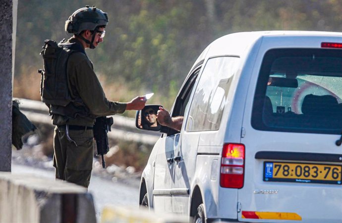 Archivo - July 6, 2023, Nablus, West Bank, Palestine: An Israeli soldier checks the phones of Palestinians who pass through an Israeli military point, near the site of the shooting of an Israeli soldier at the gate of the Jewish settlement of Kedumim in t