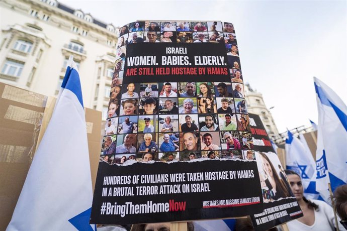 Archivo - Una persona sujeta un cartel con los rostros de las personas secuestradas durante una manifestación por la liberación de los rehenes secuestrados por Hamás, frente al Congreso de los Diputados, a 22 de octubre de 2023, en Madrid (España).
