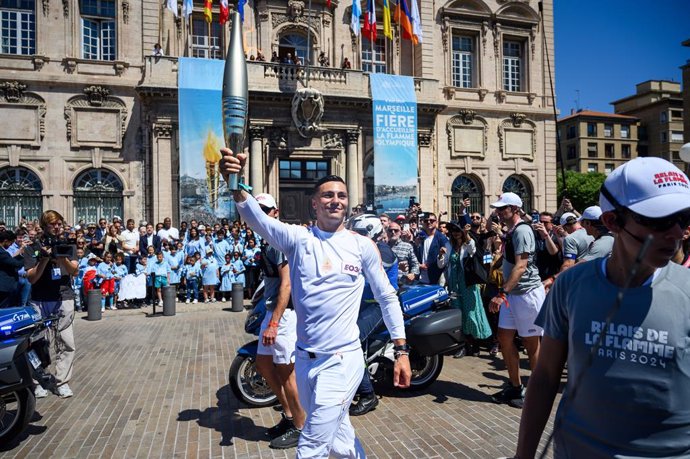 MARSEILLE, May 9, 2024  -- Local firefighter and torch bearer Matthieu Gudet holds the Olympic Torch during the relay of the Olympic flame of Paris 2024 in Marseille, France, May 9, 2024.,Image: 871437330, License: Rights-managed, Restrictions: , Model Re