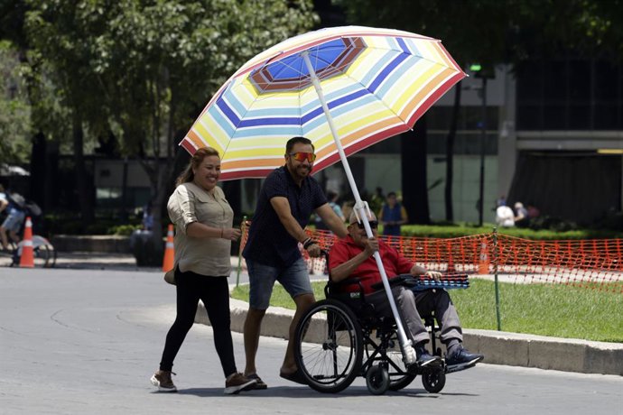 Archivo - 18 June 2023, Mexico, Mexico City: People use a large umbrella to protect themselves from the sun. The government of Mexico City activates the Orange Alert during the third heat wave with temperatures of 31 to 33 degrees Celsius in Mexico City. 