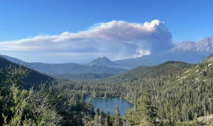 Una columna de humo de un incendio forestal se eleva sobre Castle Lake, cerca del monte Shasta, el 29 de junio de 2021.