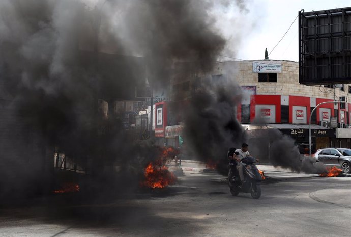 BEIJING, May 24, 2024  -- Smoke rises from burning tires during clashes in the West Bank city of Jenin on May 22, 2024. The Israeli army pulled out on Thursday from the West Bank's Jenin and its refugee camp after three days of military operation, killing