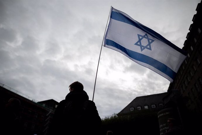 Archivo - FILED - 18 October 2023, North Rhine-Westphalia, Bochum: A man holds an Israel flag in his hand during a pro-Israeli rally on the square in front of the town hall in Bochum. Photo: Fabian Strauch/dpa