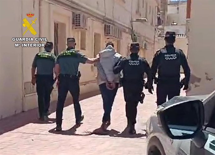 El detenido camina por una calle tras ser arrestado por efectivos de la Guardia Civil y la Policía Local de Mula