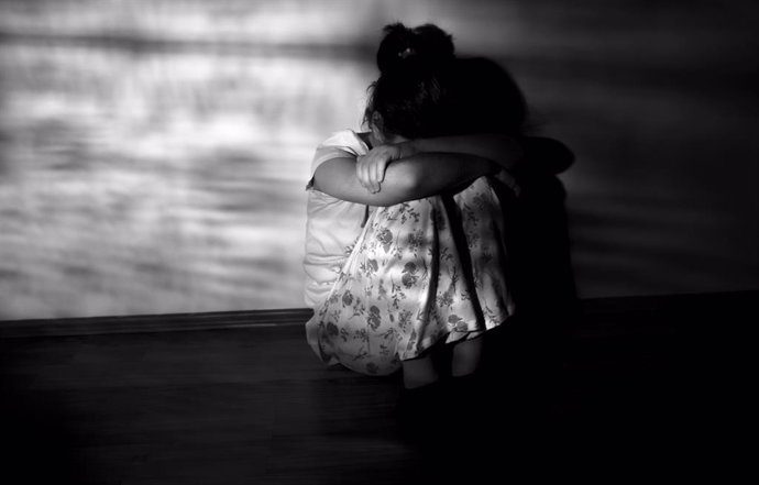 Archivo - Anxiety of a child concept, little girl sitting in the floor, dark room, stock photo