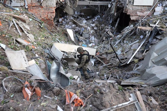 May 25, 2024, Kharkiv, Ukraine: KHARKIV, UKRAINE - MAY 25, 2024 - A law enforcer explores a crater at an office building destroyed by a Russian missile strike in central Kharkiv, northeastern Ukraine.