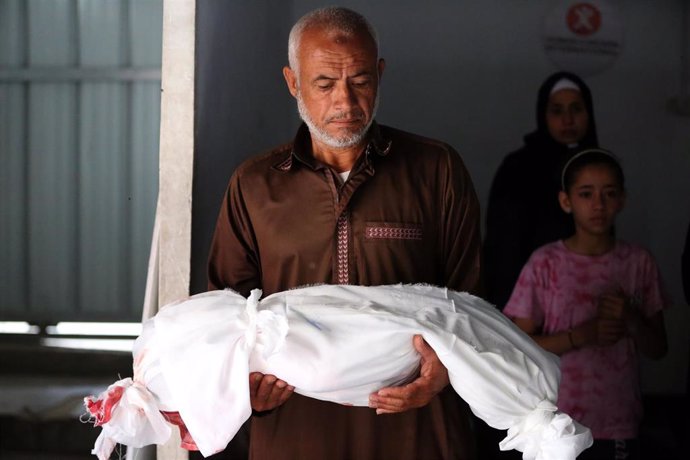 Un hombre sostiene el cadáver de un niño, víctima de los ataques de Israel sobre Gaza.