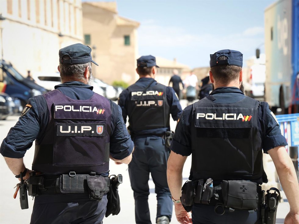 Archivo - Agentes de la Policía Nacional de espaldas.
