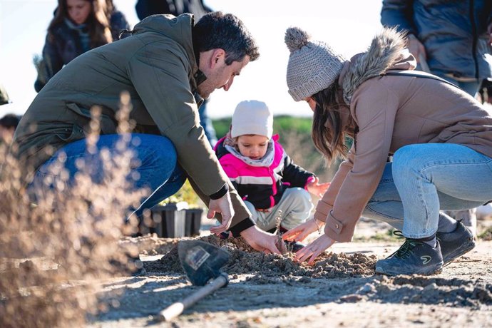 Una familia de Aedas Homes plantando un árbol en la parcela de Cobeña