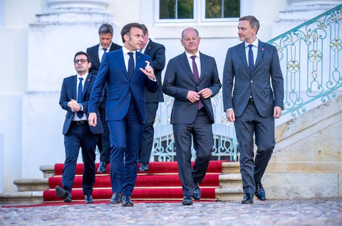 28 May 2024, Brandenburg, Gransee: Federal Chancellor Olaf Scholz (C), walks next to Emmanuel Macron (L), France's President, and Christian Lindner, Germany's Finance Minister, for a family photo at the Franco-German Ministerial Council in front of Schlos
