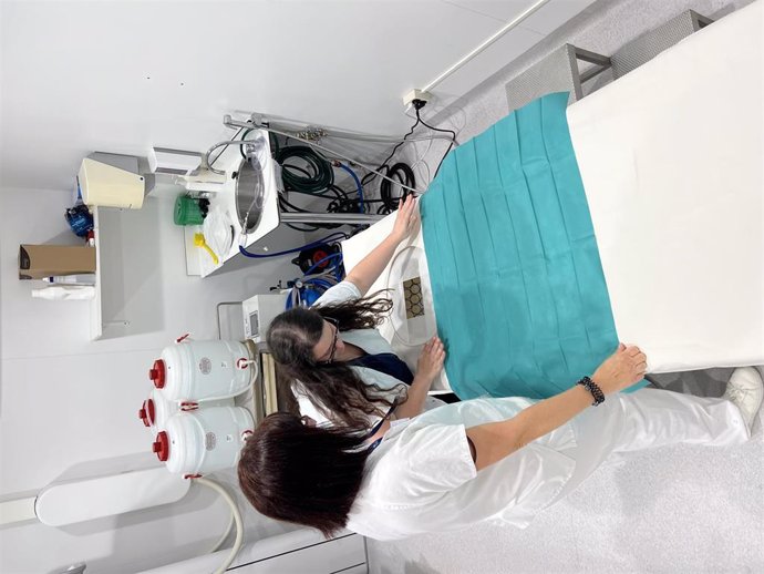 Profesionales del Hospital Vall d'Hebron preparando la cama donde una paciente participará en la validación clínica de la nueva técnica sin radiación para diagnosticar el cáncer de mama, iniciada por el BSC en el marco del proyecto QUSTom
