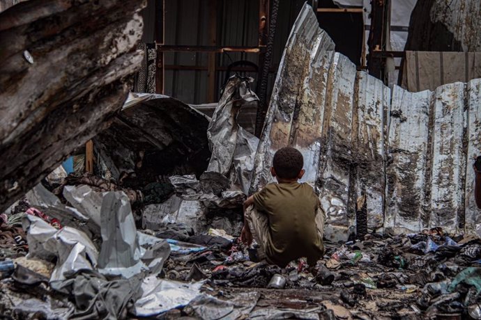 Un niño entre los restos de tiendas de campaña quemadas en la Franja de Gaza