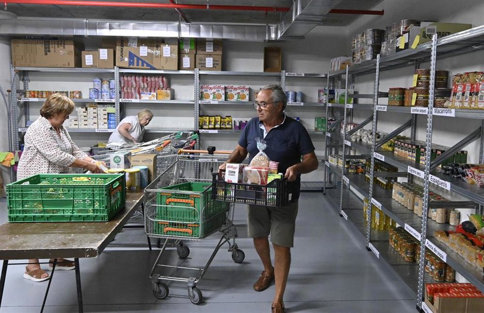 Archivo - Personas preparando productos en un banco de alimentos.