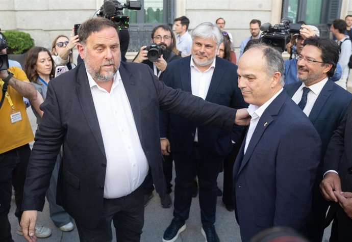 El presidente de ERC, Oriol Junqueras (i) y el secretario general de Junts, Jordi Turull (d), se saludan tras quedar aprobada la Ley de Amnistía en el Congreso de los Diputados