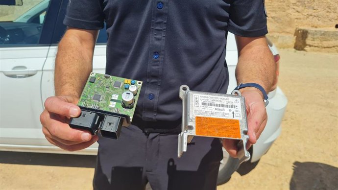 Un policía sostiene la herramienta que permite escanear los datos del coche en caso de accidente grave.