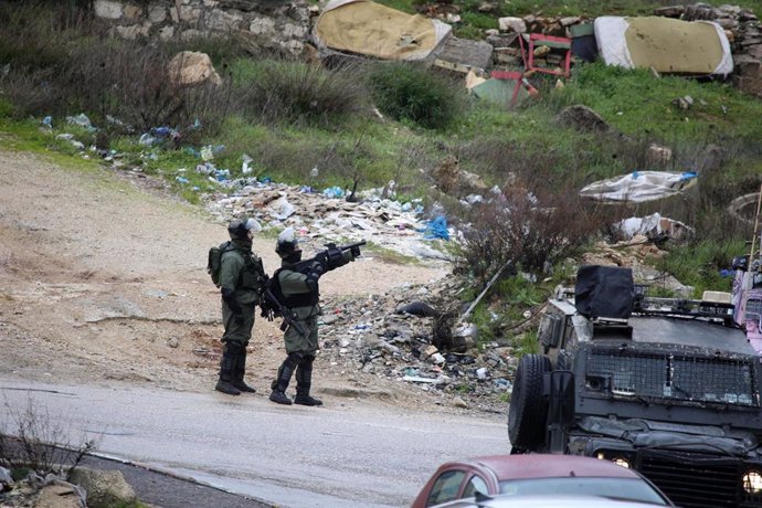 Archivo - Un militar israelí lanza gases lacrimógenos en Ramala