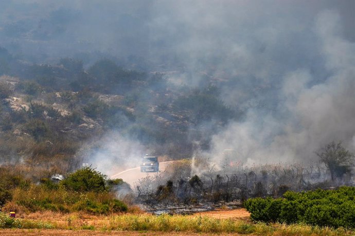 HULA VALLEY, May 23, 2024  -- Smoke rises from a hill hit by rockets fired from Lebanon, in Hula Valley in Israel, on May 23, 2024. Five Hezbollah members were killed and five others were injured on Monday in Israeli air strikes on several villages and to