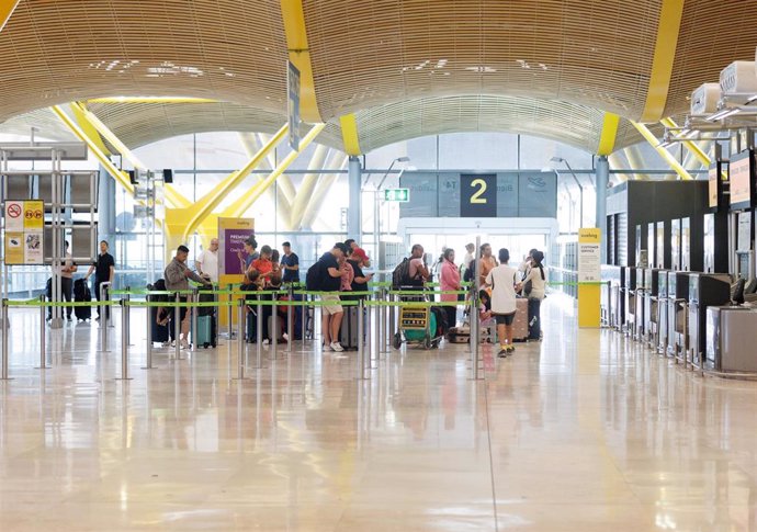 Archivo - Un grupo de personas esperan al acceso del control de la Terminal T4 del Aeropuerto Adolfo Suárez-Madrid Barajas