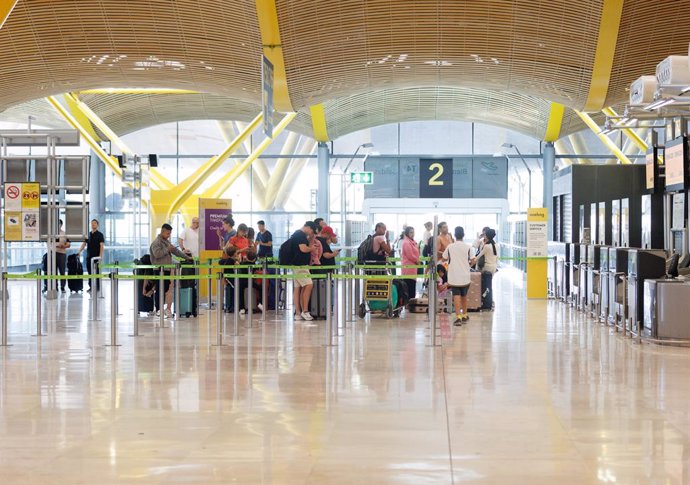 Archivo - Un grupo de personas esperan al acceso del control de la Terminal T4 del Aeropuerto Adolfo Suárez-Madrid Barajas con motivo de la operación salida de inicios de agosto, a 28 de julio de 2023, en Madrid (España).La red de aeropuertos de Aena prev