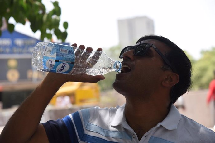 Un home beu aigua a Nova Delhi durant l'ona de calor