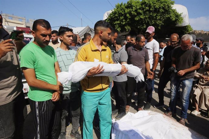 Un ciudadano palestino acarrea con el cuerpo sin vida de un familiar, víctima de los ataques de Israel sobre la Franja de Gaza.