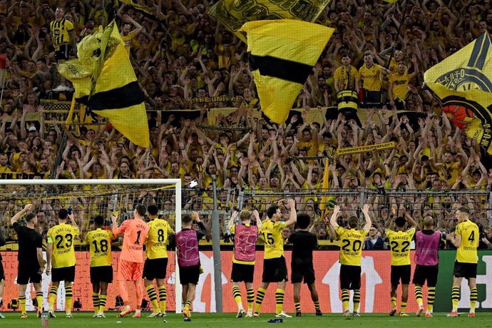 Los jugadores del Borussia Dortmund celebran la victoria en la ida de semifinales ante el PSG (1-0) junto al 'muro amarillo'.