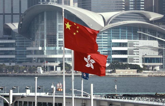 May 16, 2024, Hong Kong, CHINA: In Hong Kong, PRC red flag and HKSAR official flag flying side by side at the Victoria Harbour waterfront. Behind stand HONG KONG CONVENTION CENTRE where official HANDOVER ceremony was held between PRC and Great Britain in 