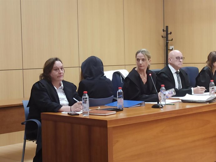 Acusada, tapada, durant el juí