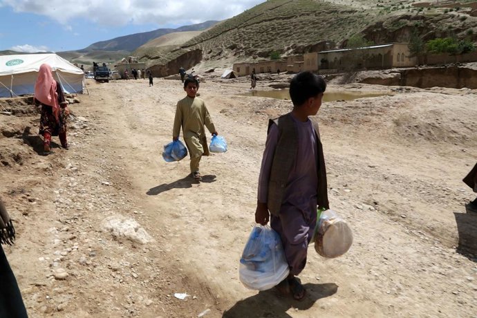 BAGHLAN, May 14, 2024  -- Children carry flood-relief materials in Borka District, north Afghanistan's Baghlan Province, May 12, 2024. About 40,000 children have lost their homes in north Afghanistan's Baghlan province as heavy downpours and floods lash
